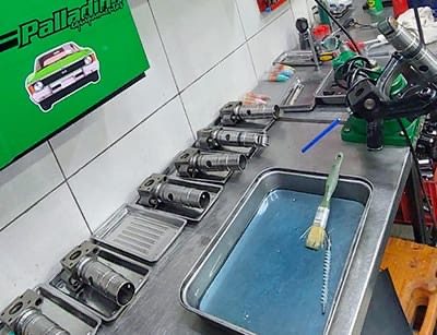 Piezas de inyectores desarmadas sobre bandejas en la mesa de trabajo