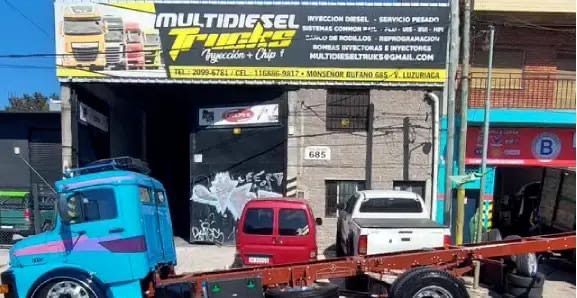 Frente del taller Multidiesel Trucks en Monseñor Bufano 685, con el cartel del local y un camión celeste estacionado en la vereda